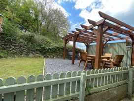 A garden with a pergola and seating area at Old Chapel House Abergwyngregyn near Llanfairfechan