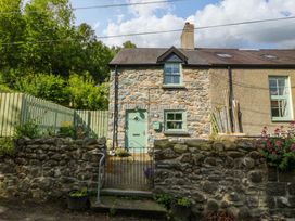 A house with a stone facade and green gate at Old Chapel House in Abergwyngregyn near Llanfairfechan