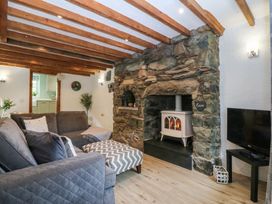 A living room with a fireplace and sofa at Old Chapel House Abergwyngregyn near Llanfairfechan
