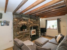 A living room with a fireplace and sofa at Old Chapel House Abergwyngregyn near Llanfairfechan