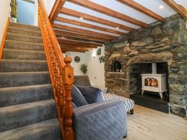 A living room with a staircase and fireplace at Old Chapel House Abergwyngregyn near Llanfairfechan