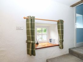 A window with curtains and decorative items on the sill at Old Chapel House Abergwyngregyn near Llanfairfechan