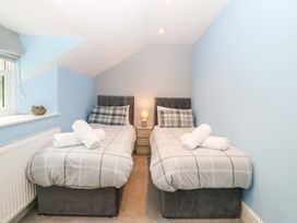 A bedroom with twin beds and a lamp at Old Chapel House in Abergwyngregyn near Llanfairfechan