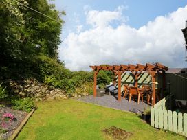A garden with a pergola and dining area at Old Chapel House Abergwyngregyn near Llanfairfechan