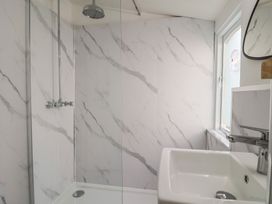A bathroom with a shower and sink at Riverdance Cottage in Lyme Regis