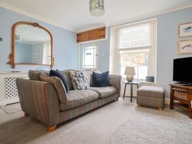 A living room with a sofa and a mirror at Riverdance Cottage in Lyme Regis