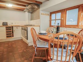 A kitchen with a dining table and chairs at Riverdance Cottage in Lyme Regis