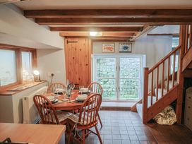 A dining area with a table and chairs at Riverdance Cottage in Lyme Regis