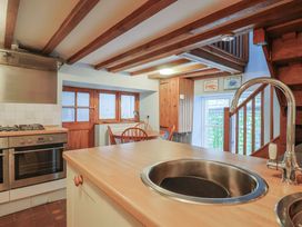 A kitchen with a stove and sink at Riverdance Cottage in Lyme Regis
