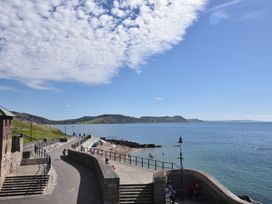 A coastal view with water, beach, and pathway at Riverdance Cottage in Lyme Regis