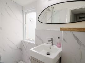 A bathroom with a sink and mirror at Riverdance Cottage in Lyme Regis