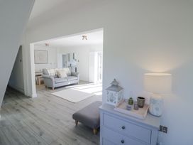 A living room with a gray sofa a rug and a blue chest of drawers with a lamp and decorative items at New House Farm in Wappenbury near Leamington Spa