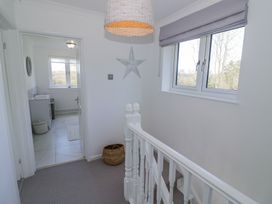 A stair landing with a window and a star wall decoration next to a bathroom at New House Farm in Wappenbury near Leamington Spa