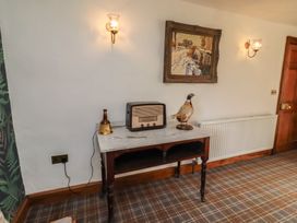 A snug room with a table and a radio at The Coach House Crookham near Cornhill-On-Tweed