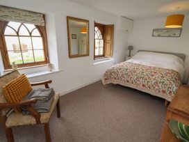 A bedroom with a bed and windows at The Coach House in Crookham near Cornhill-On-Tweed