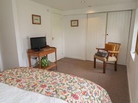 A bedroom with a bed and a television on a table at The Coach House Crookham near Cornhill-On-Tweed