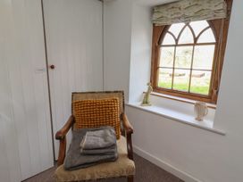 A chair with cushions and towels in a sitting room at The Coach House Crookham near Cornhill-On-Tweed