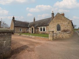 A stone house with a garden and pathway at The Coach House in Crookham near Cornhill-On-Tweed