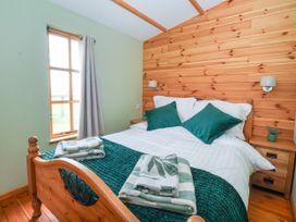 A bedroom with a bed and window at Lodge 1 in York