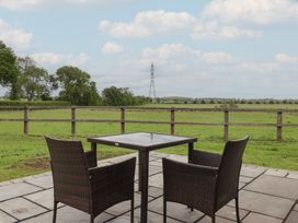 A patio with a table and chairs overlooking a field at Lodge 1 in Strensall