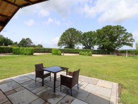 A patio with a table and chairs overlooking a grassy area at Lodge 2 in York