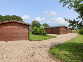 A view of wooden lodges with a gravel path in Lodge 3 York