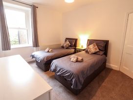 A bedroom with two single beds and a nightstand at 7 Lonsdale Terrace Penrith