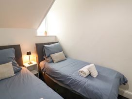 A bedroom with two beds and a lamp at 7 Lonsdale Terrace in Penrith