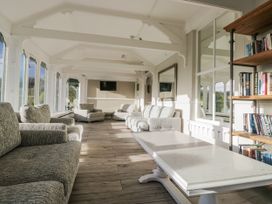 A conservatory with sofas and a TV at Valley View in Dalton-In-Furness