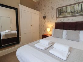 A bedroom with a bed and wardrobe at Bridlington Bay House in Bridlington