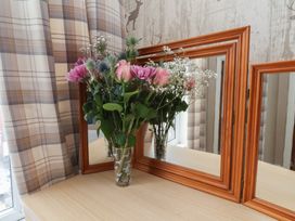 A vase with flowers and mirrors on a table at Bridlington Bay House in Bridlington