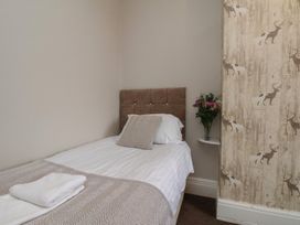 A bedroom with a bed, pillows, and a flower vase at Bridlington Bay House in Bridlington