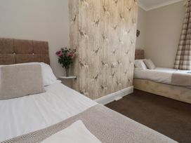 A bedroom with two beds and a flower vase at Bridlington Bay House in Bridlington