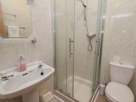 A bathroom with a shower, toilet, sink and mirror at Bridlington Bay House in Bridlington