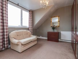 A bedroom with a sofa and a dresser at Bridlington Bay House in Bridlington