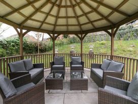 A gazebo with seating area in the garden at Beechgrove Manor in Workington