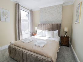 A bedroom with a double bed curtains bedside tables and lamps at 6 Canning Road in Colwyn Bay