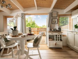 A dining area with a table, chairs, and a sliding door to the garden at Hazel in Blandford Forum