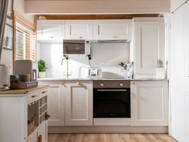 A kitchen with cabinets, sink, toaster, and oven at Hazel in Blandford Forum