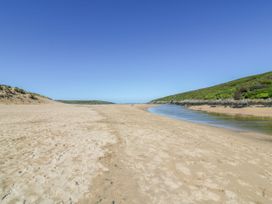 A beach with a river and hills at Newquay Tamarisk Lodge on the Gannel Newquay