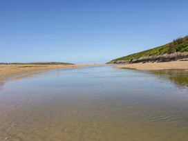 A beach with water and hills at Newquay Tamarisk Lodge on the Gannel Newquay