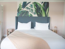A bedroom with a bed and a wall mural at Newquay Tamarisk Lodge on the Gannel Newquay