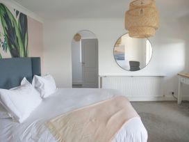 A bedroom with a bed and a mirror at Newquay Tamarisk Lodge on the Gannel, Newquay