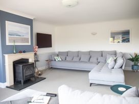 A living room with a sofa and television at Newquay Tamarisk Lodge on the Gannel Newquay