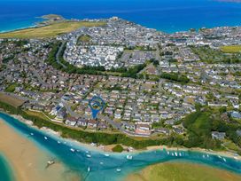An aerial view of houses near a beach and river at Newquay Tamarisk Lodge on the Gannel in Newquay