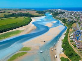 A river with boats and houses along the bank at Newquay Tamarisk Lodge on the Gannel in Newquay