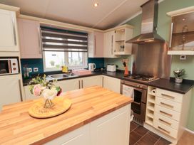 A kitchen with a stove and microwave at Rosie's Zen Den High Hesket near Armathwaite