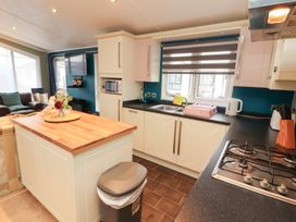 A kitchen with a gas stove and sink at Rosie's Zen Den in High Hesket near Armathwaite
