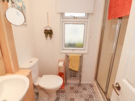 A bathroom with a sink, toilet, shower and window at Rosie's Zen Den in High Hesket near Armathwaite