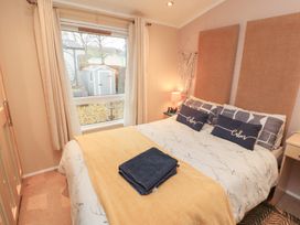 A bedroom with a bed and window view at Rosie's Zen Den near High Hesket